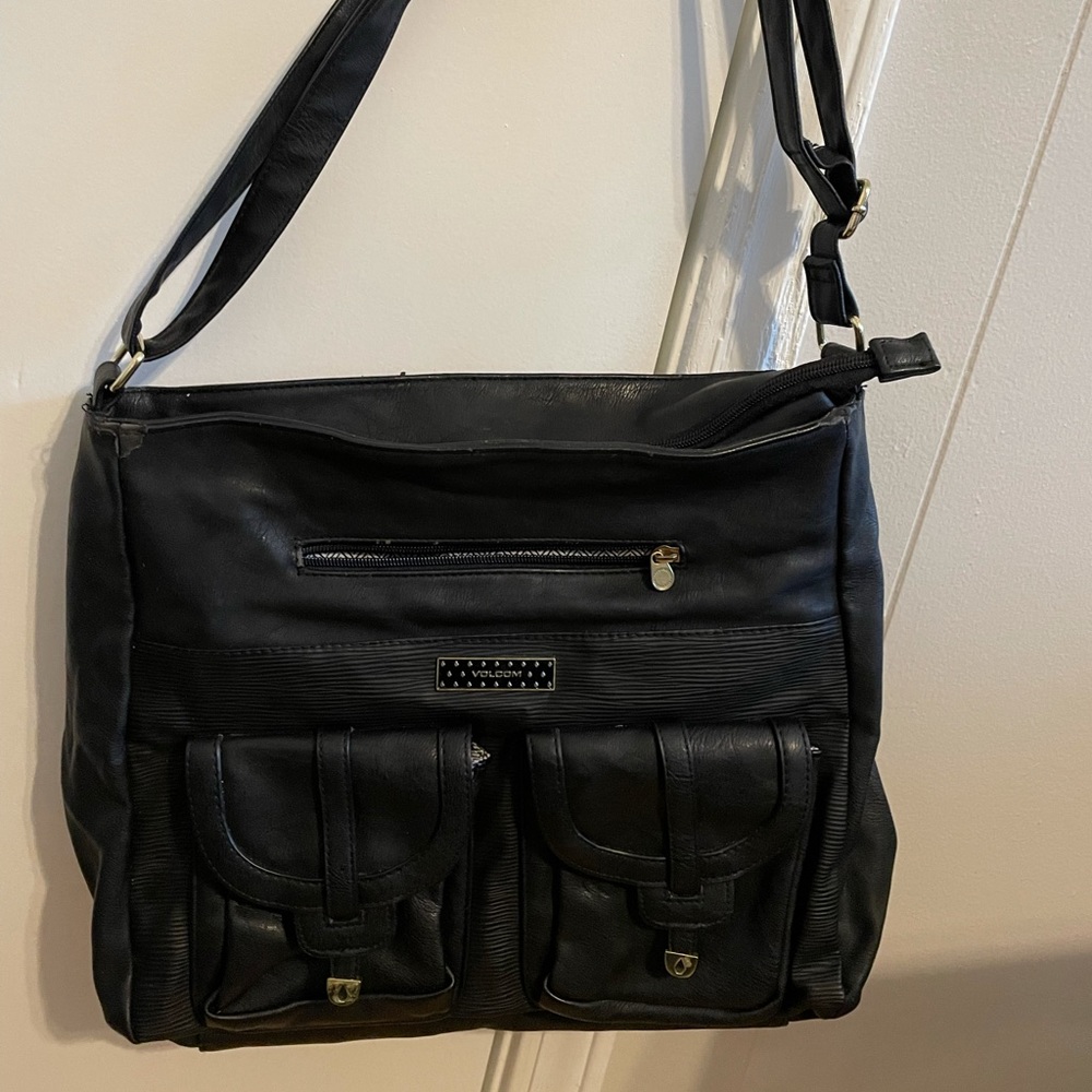 Black Volcom bag. Three outside pockets, one inside zippered pocket.